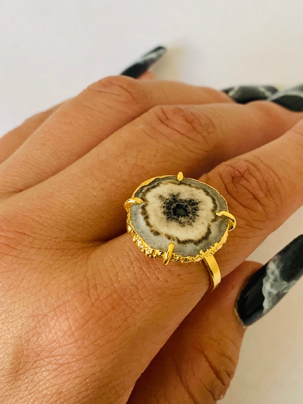 This adjustable statement oval stone ring features a black onyx gem. Set in a 22K gold and brass casing. this oval stone ring is the perfect centerpiece of a sharp look. Get your fingers wrapped around this classy onyx statement ring.  Product Details  Composition: 22k gold-plated brass, onyx gem Adjustable Handmade in Morocco Please note the possibility of natural inclusions in gemstones