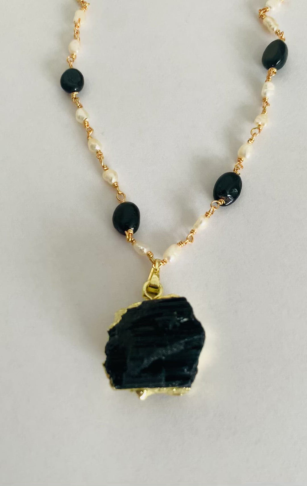 A beautiful hand made necklace. This gold plated pendant necklace for women comes with pearls and black onyx.  Product Details  Composition: 22k gold-plated brass, onyx, fresh water pearls 18 inches with 3 inch extender  Handmade in Morocco Please note the possibility of natural inclusions in gemstones